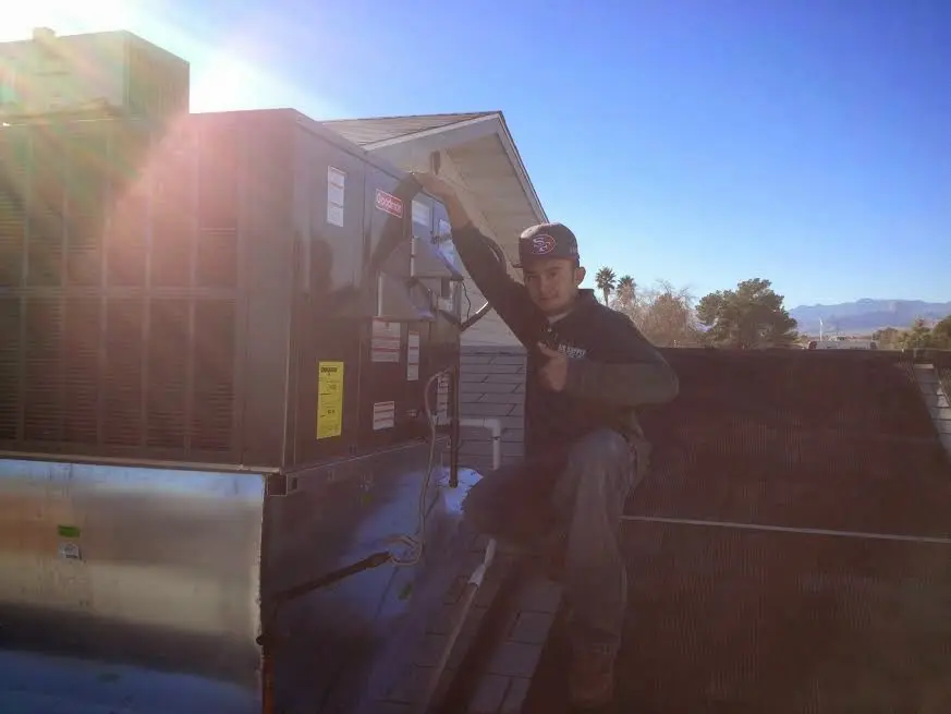 HVAC technician performing AC Tune-Up on a rooftop unit in Avon
